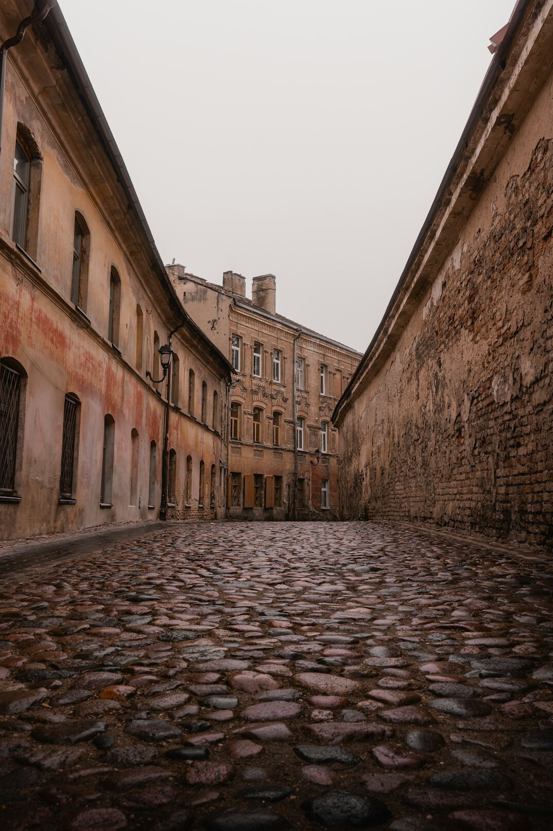 Foggy cobblestone street in an old European town at dusk
